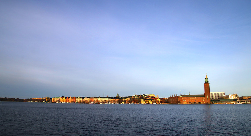 En vy över Stockholms stadshus med Riddarfjärden i förgrunden.