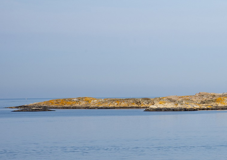 Klippor vid havet med klarblå himmel.