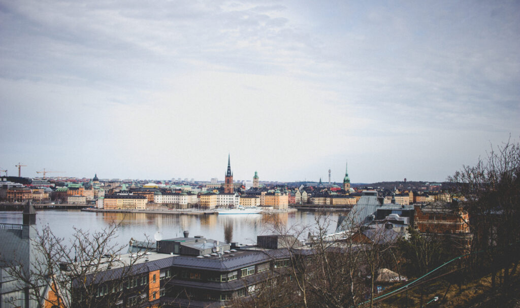 En siluett av Stockholm, med många äldre byggnader, kyrkor och en sjö.